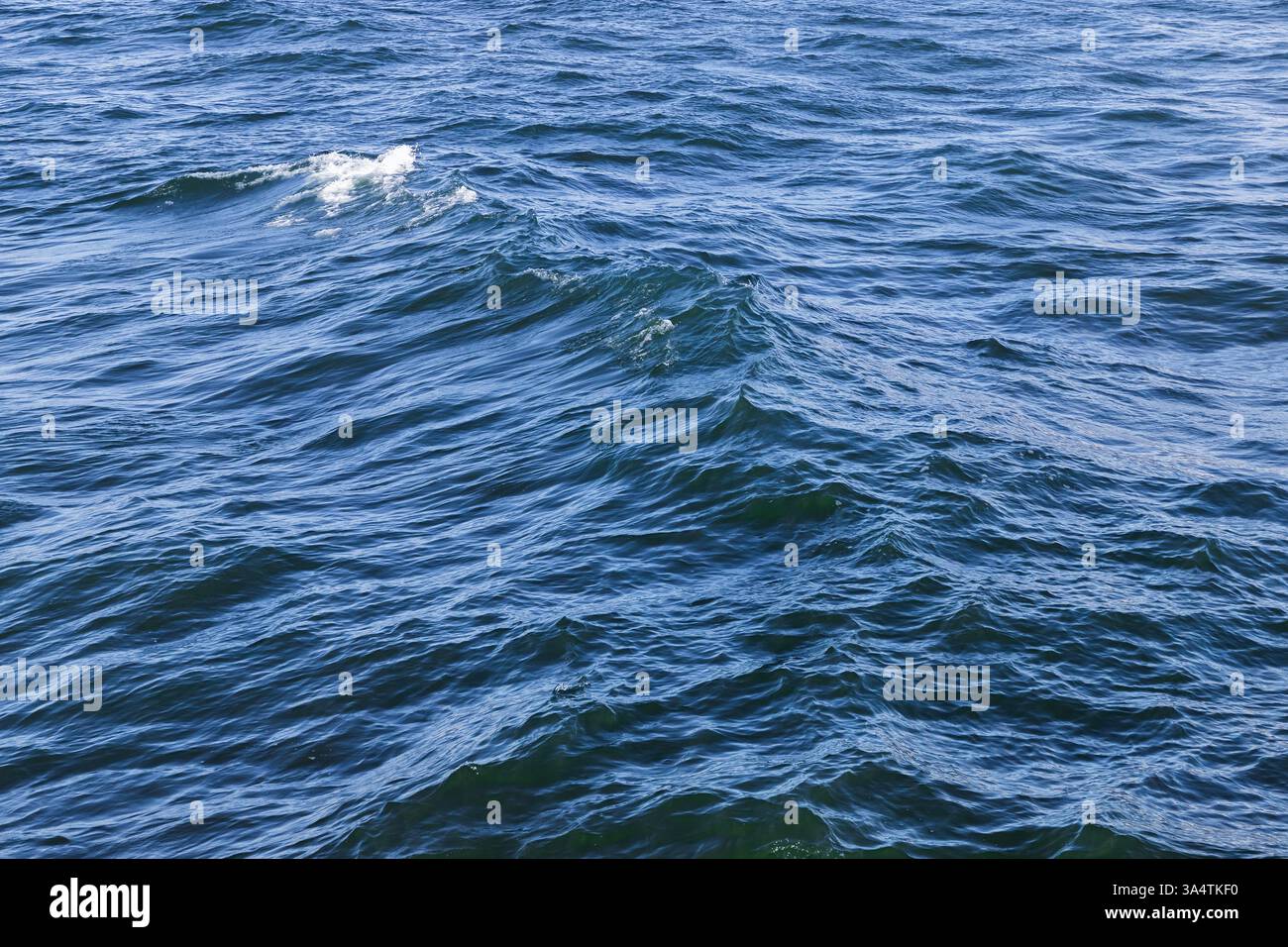 Le onde e le onde dolci creano un'atmosfera rilassante e tranquilla sulla superficie blu dell'oceano. Il tranquillo ambiente marino trasmette serenità, bellezza e danni Foto Stock