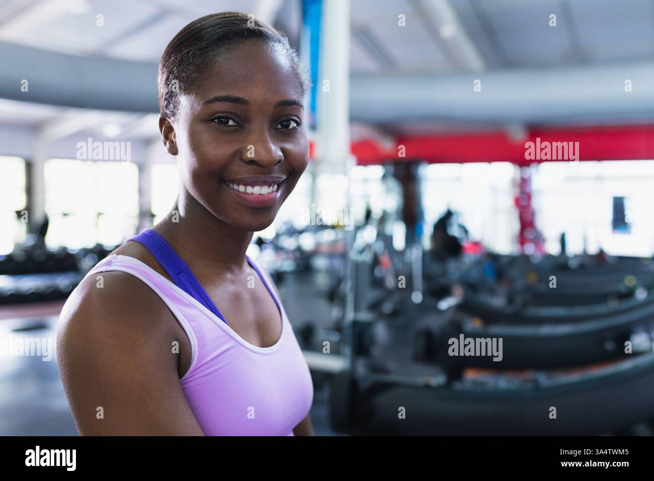 Donna sicura di sé in palestra sorridente, in piedi vicino ai tapis roulant, pronta per l'allenamento, spazio fotocopie Foto Stock