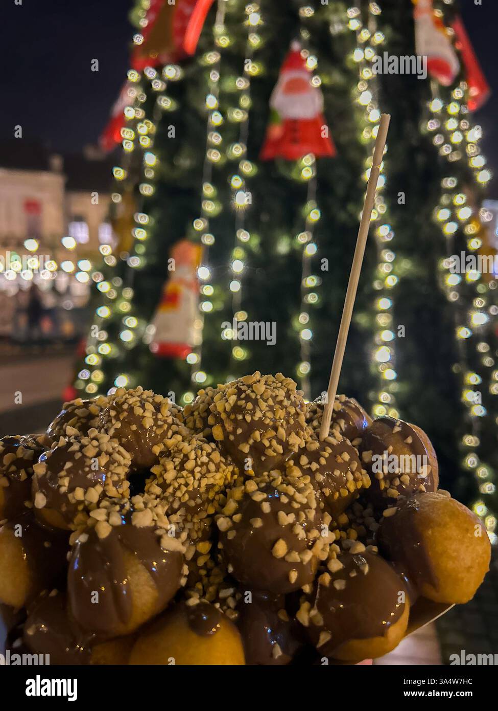 Deliziose frittelle condite con ricco cioccolato e nocciole croccanti, servite con decorazioni natalizie sullo sfondo. - Immagine stock catturata con smartphone