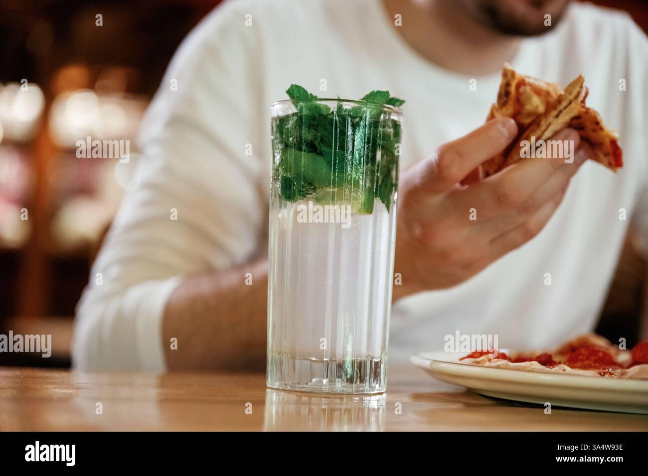 Vista ravvicinata dell'uomo che sta mangiando pizza, seduto. Foto Stock