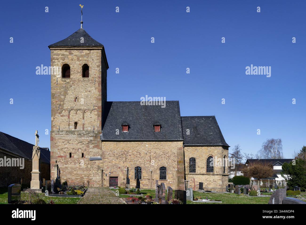 l'antica chiesa di wollersheim con la sua torre di fine xi secolo, realizzata in muratura di pietra da cava intervallata dai resti di mattoni romani Foto Stock