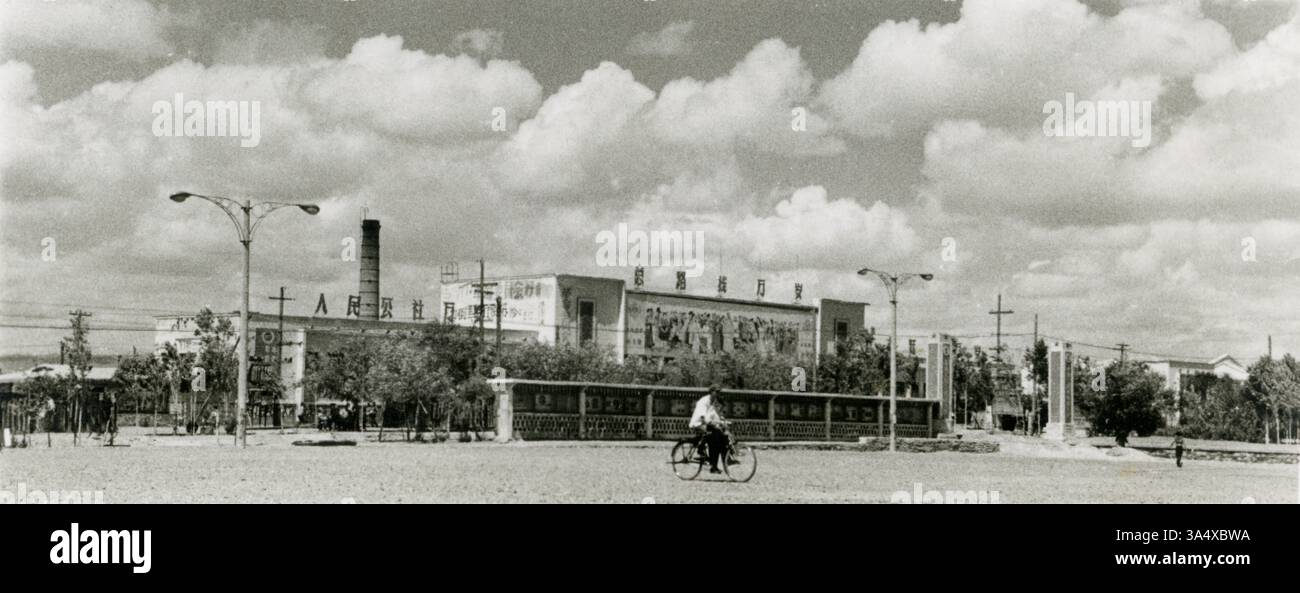 L'era rivoluzionaria del commercio: Il negozio Dongfanghong a Karamay, Xinjiang, sotto la bandiera dei comuni del popolo, il grande salto in avanti e la strada socialista, dalla fine degli anni '1960 all'inizio degli anni '1970 La foto è stata scattata tra la fine degli anni '1960 e l'inizio degli anni '1970, mostrando il negozio Dongfanghong a Karamay, Xinjiang, Cina. Lo striscione recita: "Lunga vita ai comuni del popolo, lunga vita alla linea generale, lunga vita al grande salto in avanti". Questi slogan si riferiscono alla politica generale della costruzione socialista nota come linea generale, il grande balzo in avanti e i comuni del popolo, introdotti dal Comitato centrale Foto Stock