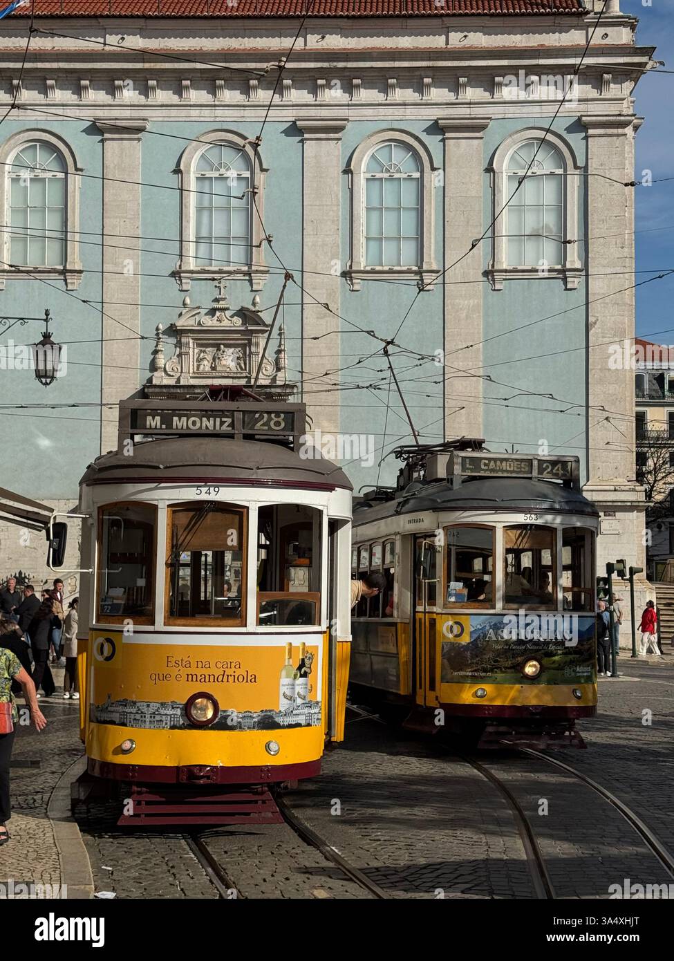 Un paio di tram d'epoca, tra cui uno sulla famosa linea 28 del tram, alla stazione finale di Camões de Luís, Chiado, Lisbona, Portogallo. - Immagine stock catturata con smartphone