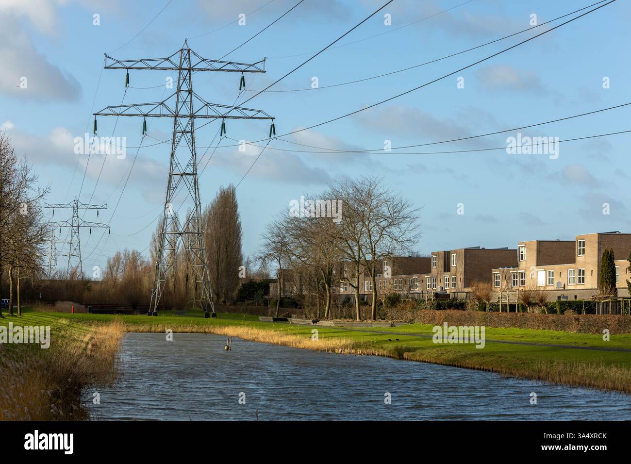 Traliccio elettrico nel mezzo di un'area residenziale con case e appartamenti familiari. La rete elettrica nei Paesi Bassi è piena. Foto Stock