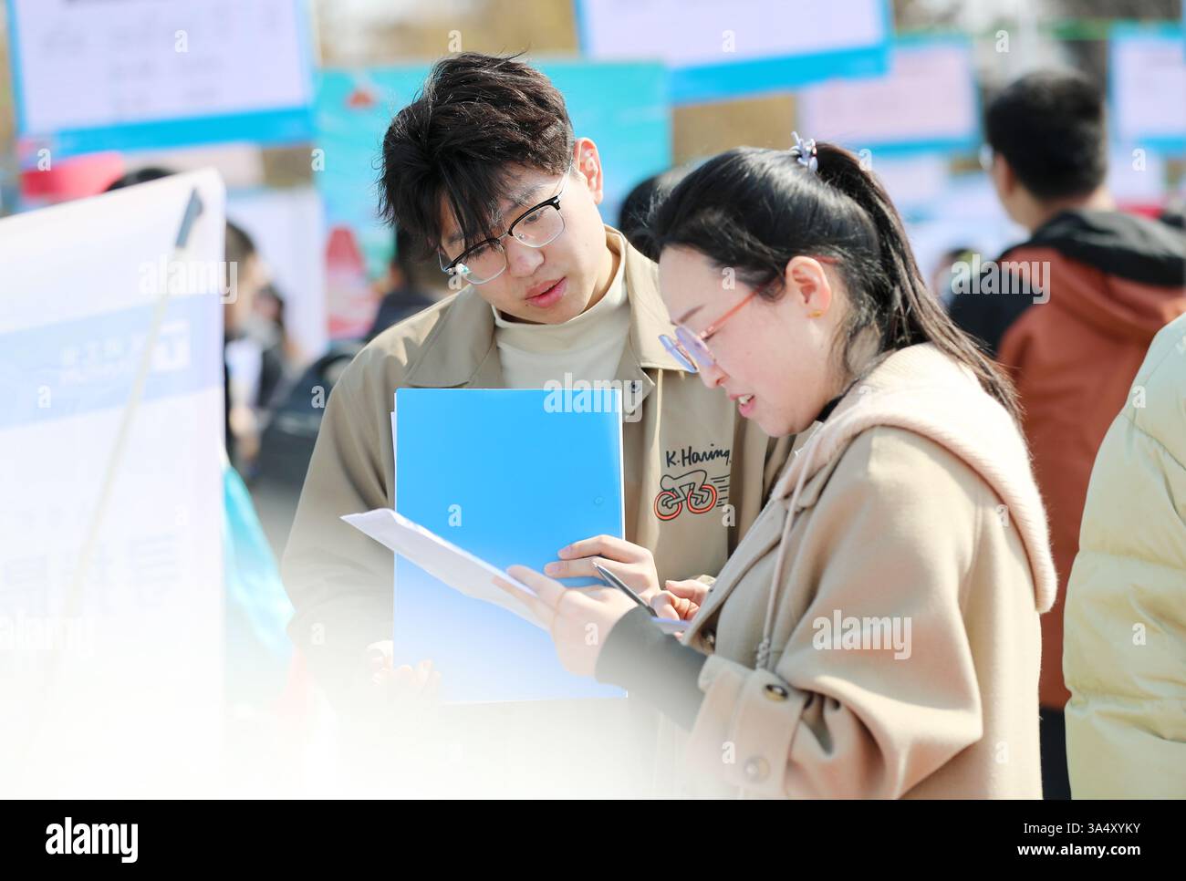 QINGDAO, CINA - 20 MARZO 2025 - gli studenti universitari comunicano con i datori di lavoro alla fiera di selezione doppia del campus della Shandong University of Science AN Foto Stock