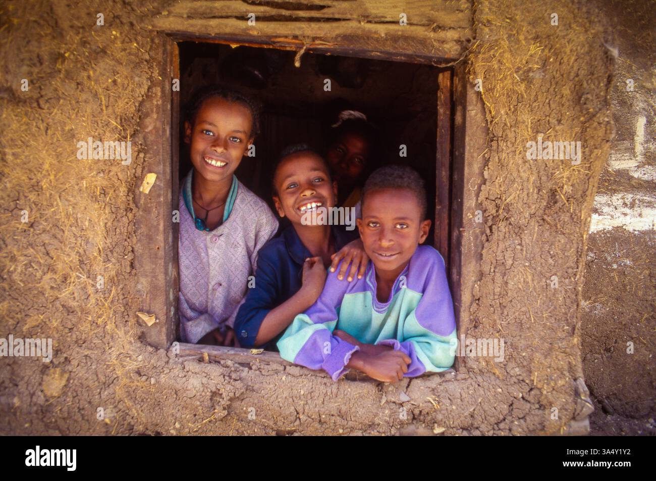 Etiopia, Addis Abeba; famiglia che guarda fuori dalla finestra di una casa di adobe. Foto Stock