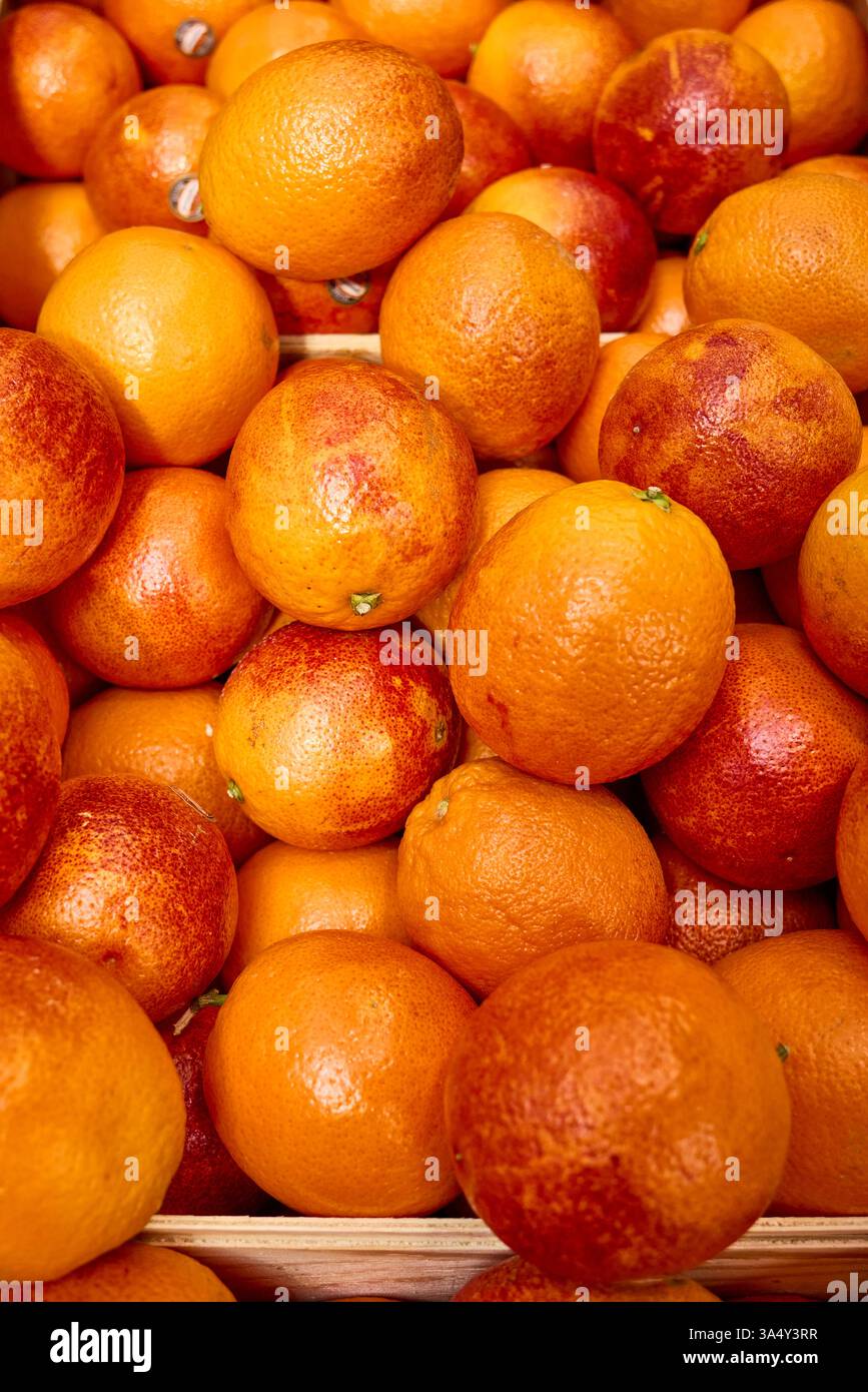 Un vivace e colorato primo piano di arance fresche in un ambiente di mercato Foto Stock