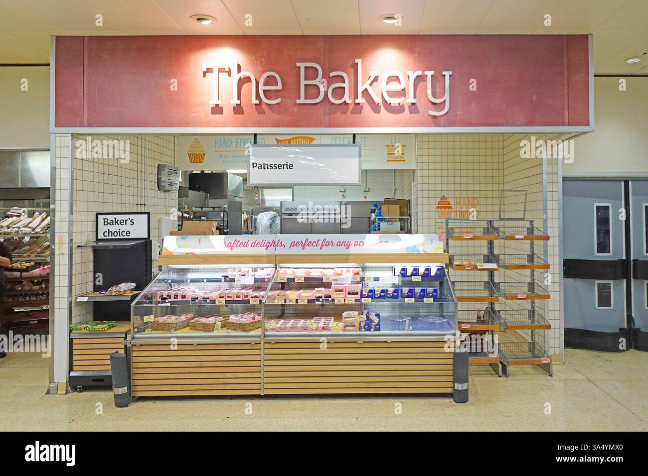 Il cartello Bakery e il bancone che espone e vende una varietà di prodotti alimentari da forno all'interno di un grande supermercato Sainsbury nella contea di Essex, Inghilterra, Regno Unito Foto Stock