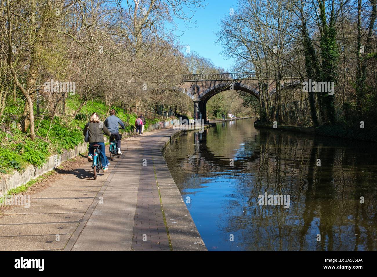 Ciclisti sul sentiero del Regents Canal vicino al Macclesfield Bridge (ponte gonfiabile), Londra, Inghilterra, Regno Unito Foto Stock