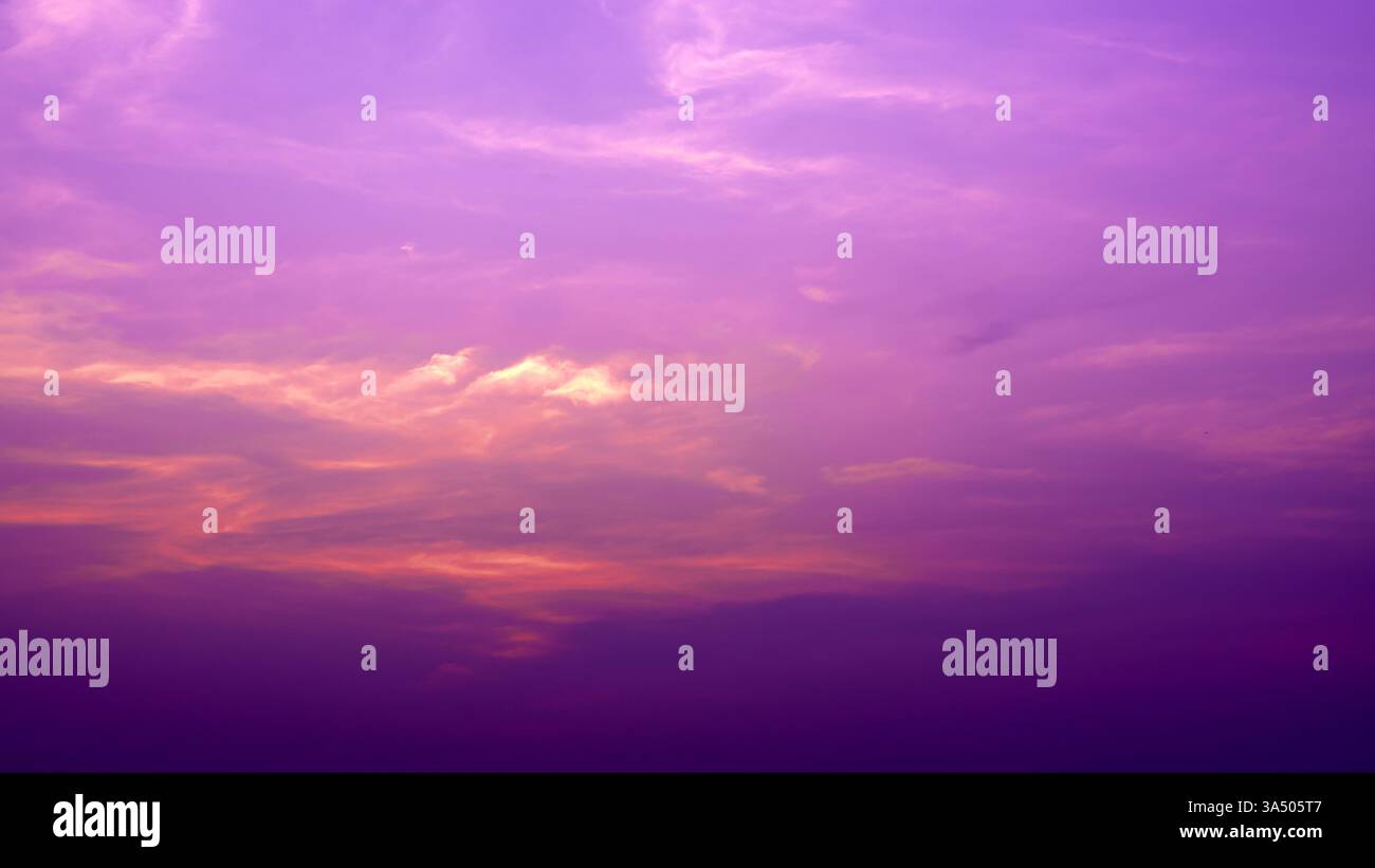 Splendido sfondo cielo color rosa pastello, arancione e viola sfumato la sera mentre il sole tramonta. Calmo cielo serale invernale. Atmosfera tranquilla del cielo serale Foto Stock