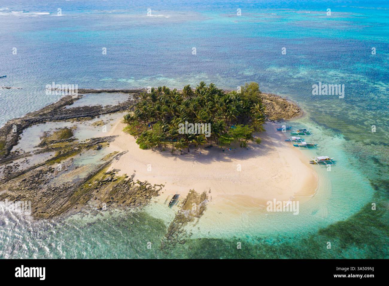 Vista aerea di un'isola tropicale con palme, sabbia bianca e mare turchese durante l'estate. Un paesaggio tranquillo e senza persone perfetto per viaggi e campagne di vacanza. Foto Stock