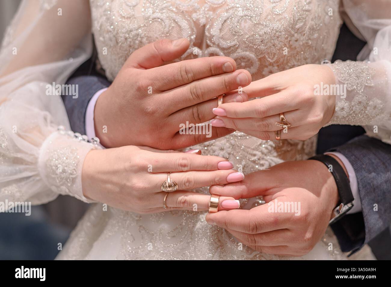 Lo sposo abbraccia la sposa mentre si scambiano con le sue fedi nuziali, simboleggiando l'amore e l'impegno. gli anelli rappresentano una promessa per tutta la vita, evidenziando l'emozione Foto Stock