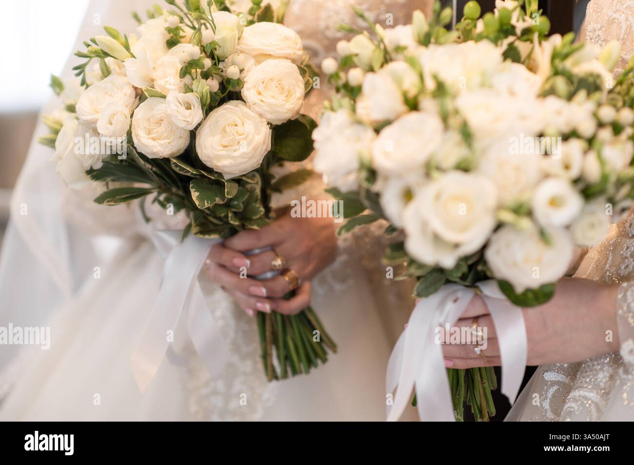 Rose bianche in mani spose, catturate in primo piano con il loro riflesso nello specchio. le rose simboleggiano la purezza e l'amore, mettendo in risalto l'eleganza e la bellezza Foto Stock