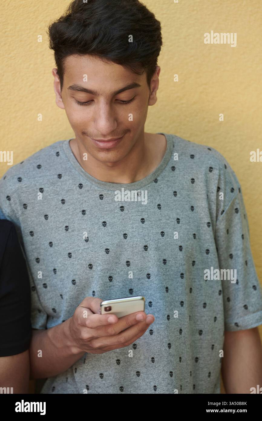 Ritratto professionale mediorientale di un giovane alla moda in un abbigliamento casual. L'ambiente urbano e lo stile moderno trasmettono un'atmosfera d'affari sicura e accessibile. Foto Stock