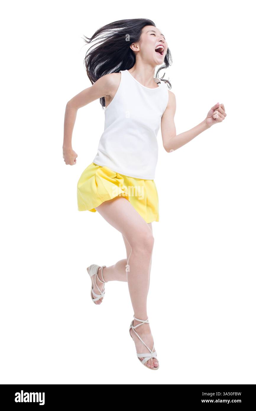 Giovane donna cinese che corre all'aperto, mostrando fitness e determinazione. Il movimento e l'energia si adattano alle campagne sportive, di benessere e di stile di vita attivo. Ideale per annunci che presentano jogging, motivazione e allenamento all'aperto. Foto Stock