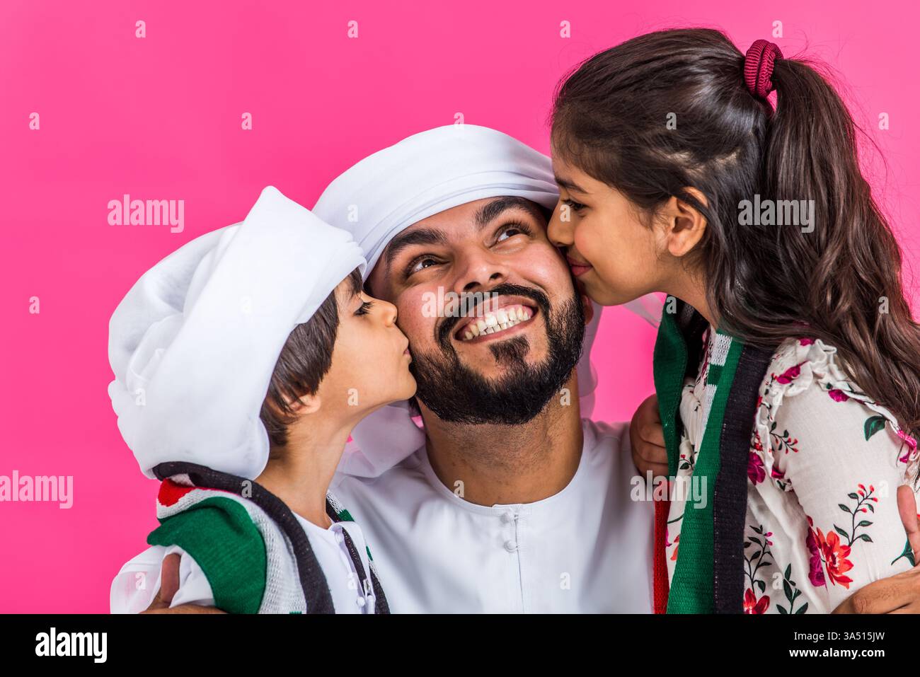 Famiglia mediorientale in abiti tradizionali degli Emirati in posa in uno studio. Questa immagine dello stile di vita trasmette felicità, legami familiari e abiti culturali. Foto Stock