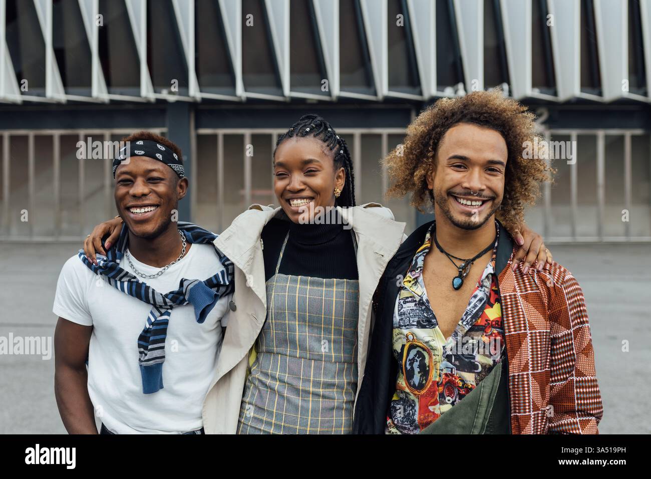 Un uomo e una donna afroamericana sorridenti si avvicinano in un caldo colpo di gruppo al chiuso. L'immagine evidenzia la diversità, il lavoro di squadra e la moderna cultura del luogo di lavoro. Foto Stock