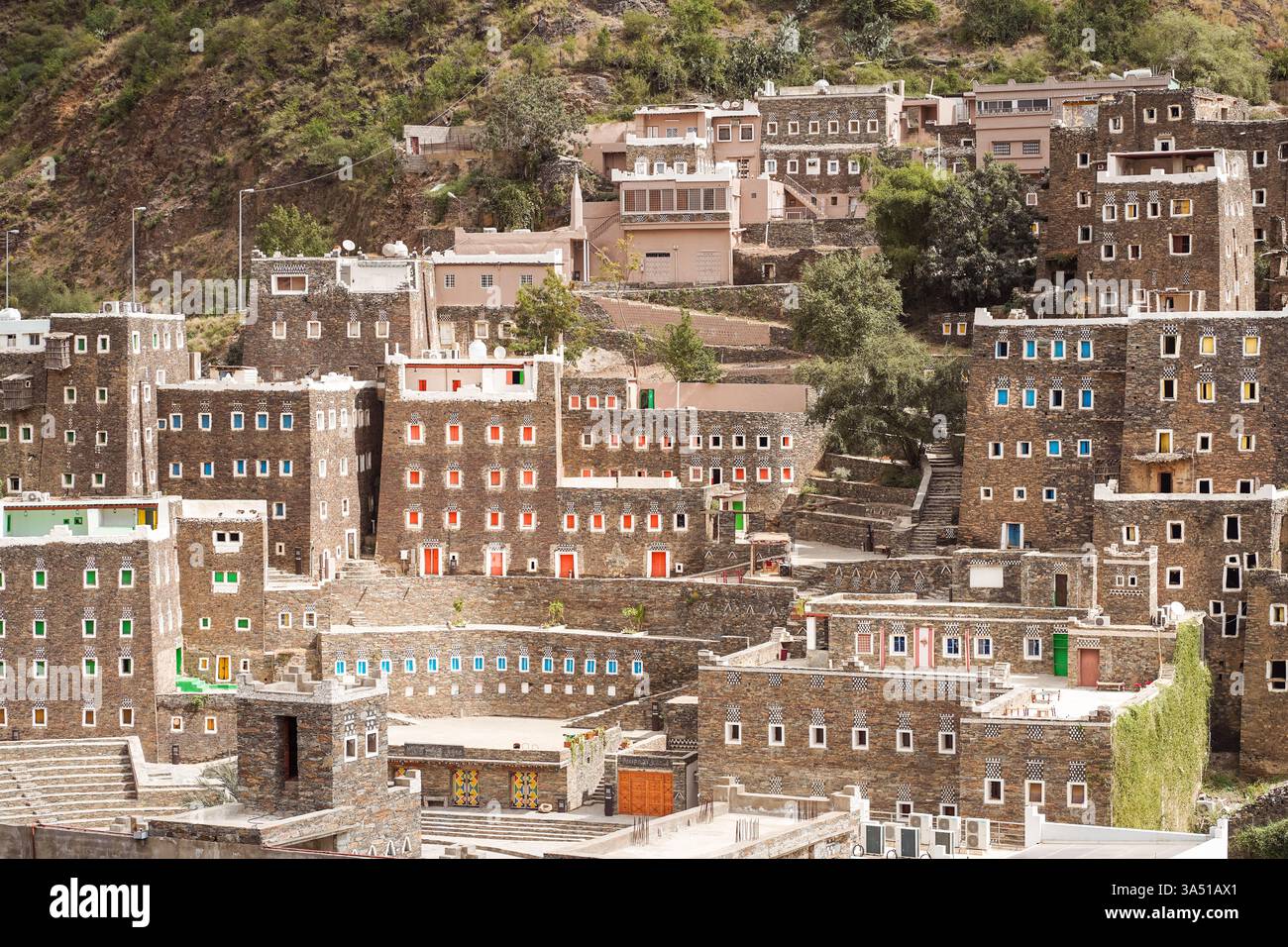 Vista spettacolare delle case in pietra invecchiata con finestre colorate a Rijal Almaa, Arabia Saudita. Questo villaggio storico è ideale per viaggi, architettura e racconti culturali, con un design storico. Perfetto per le caratteristiche di destinazione e le campagne turistiche. Foto Stock