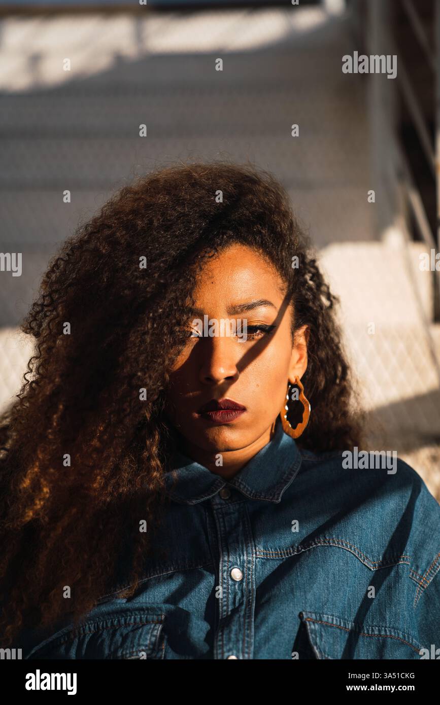 Donna afroamericana che guarda da parte, un ritratto premuroso. Pulita, con luce naturale e un'atmosfera tranquilla adatta a temi di stile di vita o benessere. Ideale per la crescita personale, la vita lavorativa moderna o le campagne ispiratrici. Foto Stock