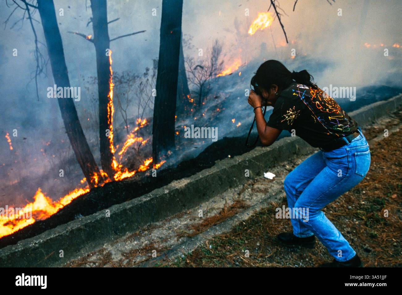 Uno studente della "Mari Sol Photo School" fotografa un incendio boschivo fuori città del Guatemala, Guatemala. Foto Stock