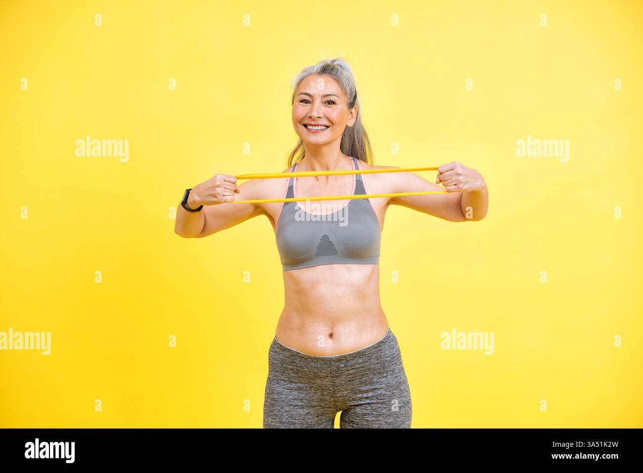 Bella donna di mezza età che si esercita in palestra, promuovendo la positività corporea e l'accettazione di sé. Perfetto per fitness, vita sana e campagne di invecchiamento graziosamente. Per il benessere, le riprese in studio e il branding lifestyle. Foto Stock