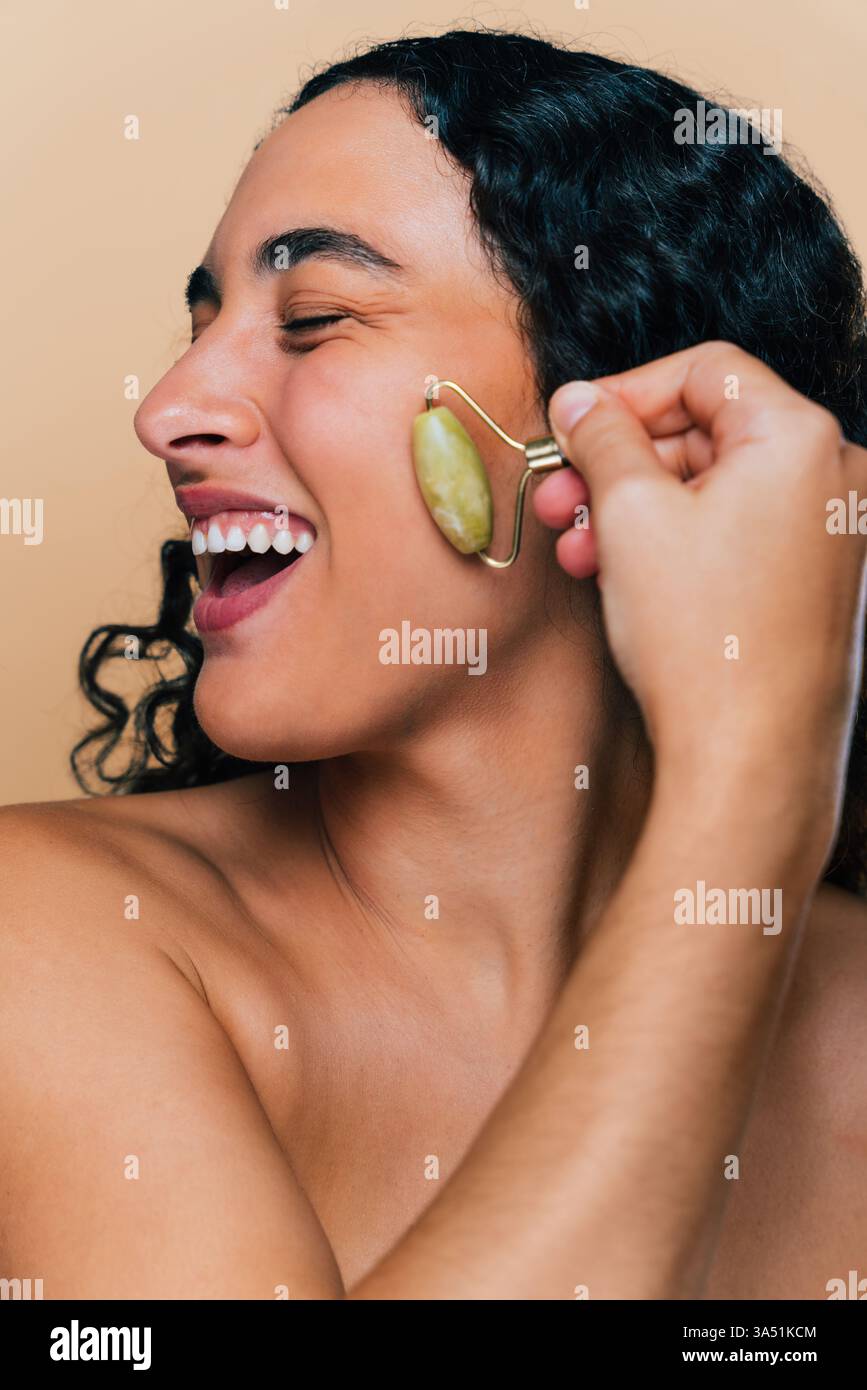 Ritratto in studio di bellezza di una giovane donna sicura di sé con un diastema. Presenta un look eterogeneo ed elegante con un'attenzione particolare alla cura della pelle. Ideale per campagne di bellezza, ritratti e temi di positività corporea. Foto Stock