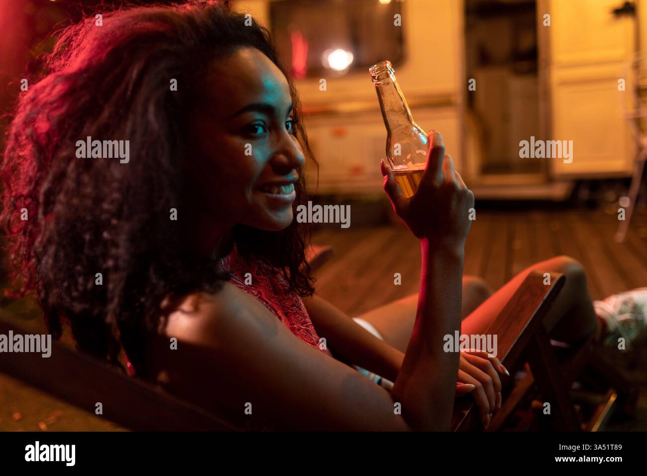 Giovane coppia in vacanza con un camper, godendosi la notte nella natura. La scena cattura la voglia di girovagare e lo stile di vita dei viaggi su strada per viaggi e campagne all'aperto. Ideale per lo stile di vita e le immagini di viaggio. Foto Stock