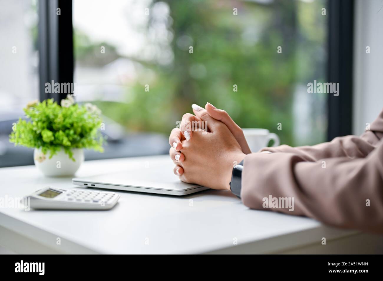 Donna d'affari asiatica con le mani di chiusura sul tavolo seduta in ufficio Foto Stock Donna d'affari asiatica con le mani di chiusura sul tavolo seduta in ufficio Foto Stock