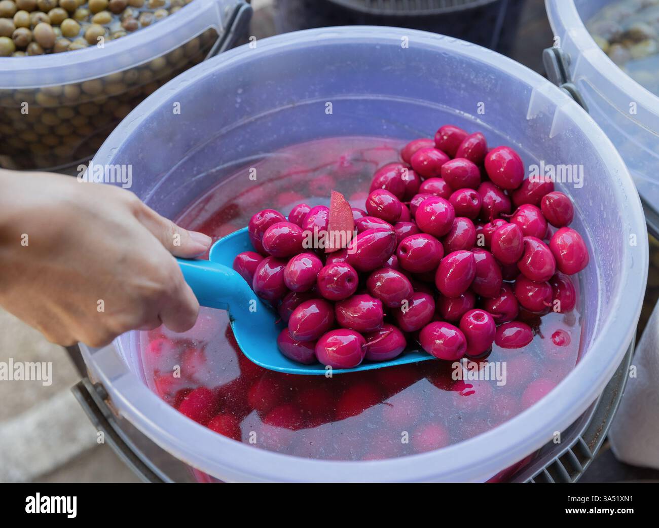 Olive rosse (speciali) vendute sul mercato. Antipasti tradizionali e prodotti per la colazione preferiti nella cucina mediterranea. Foto Stock