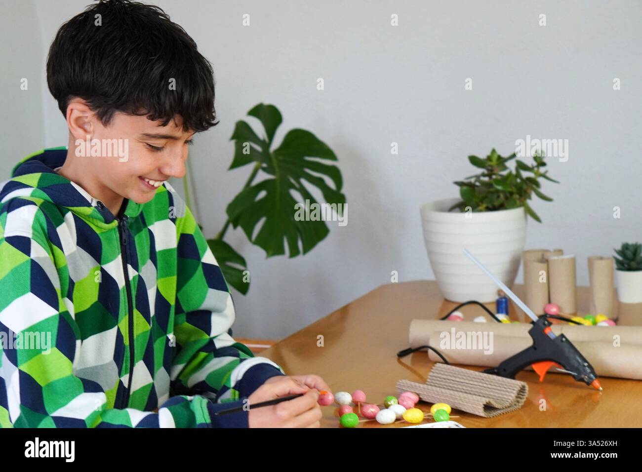 il concetto di svago senza schermi. pretteen boy happy dipingere e realizzare con materiali riciclati. Foto Stock