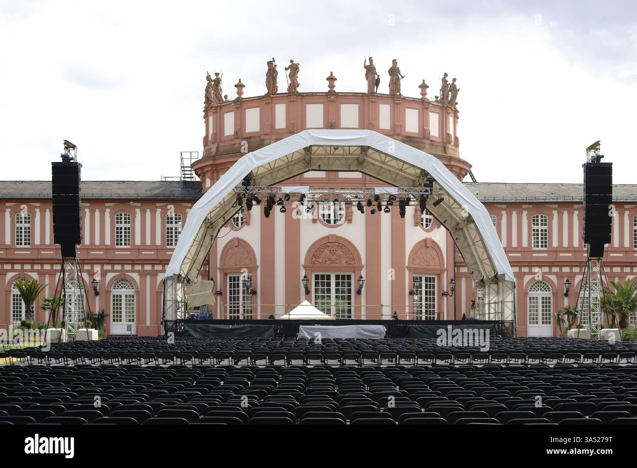Wiesbaden, Germania - 14 luglio 2016: Un palco da concerto allestito con file di posti per un concerto di musica classica nei giardini del palazzo con il Palazzo Biebrich in th Foto Stock