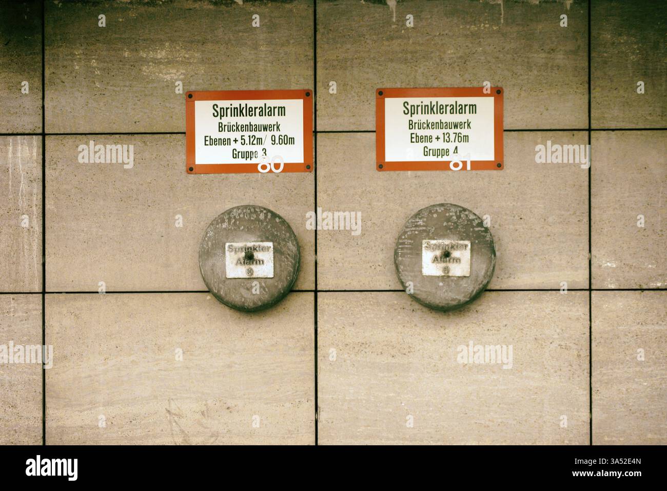I campanelli di allarme di un impianto sprinkler con cartelli su una parete sporgente Foto Stock