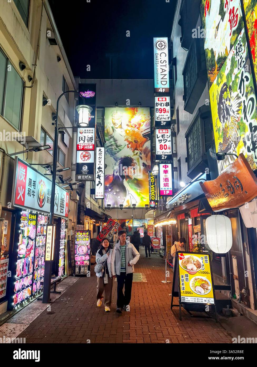 Piccola strada di notte ad Asakusa, Tokyo, con molti cartelli illuminati. Foto Stock
