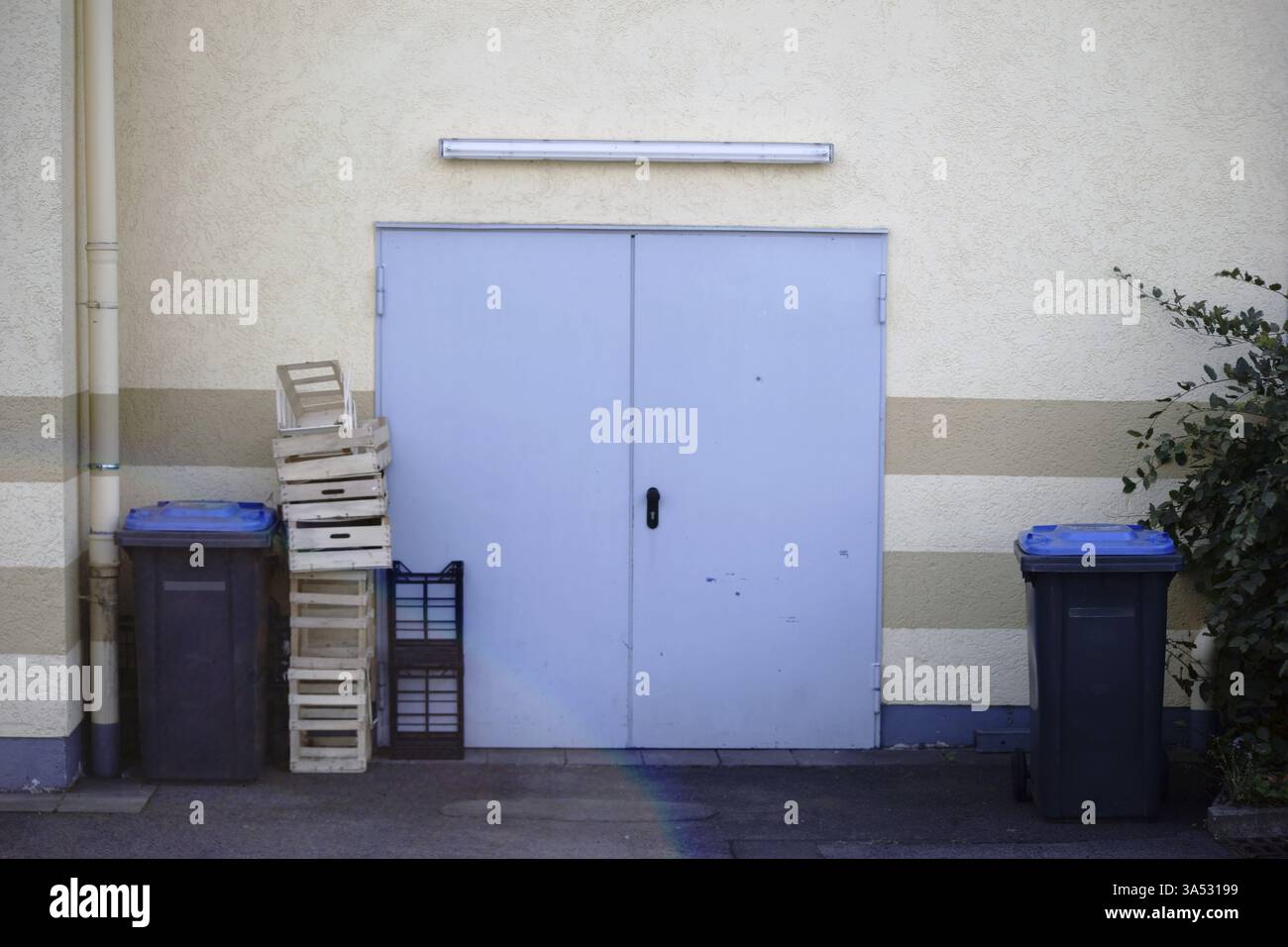 Casse di verdure impilate nel cortile di un commerciante di frutta e verdura con un reparto merci in arrivo Foto Stock