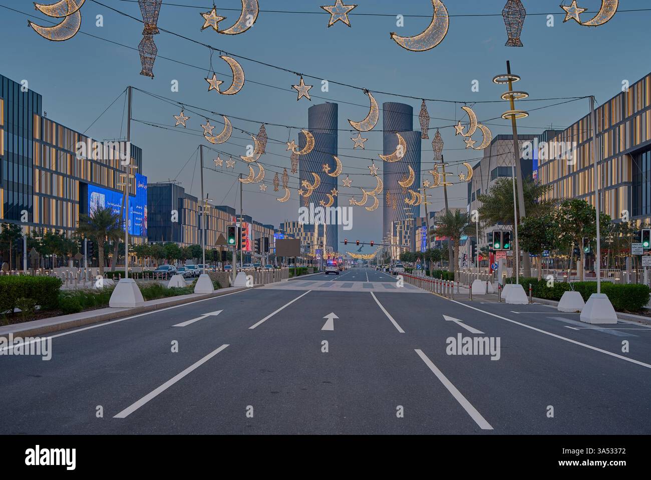 Viale Lusail nella città di Lusail, Qatar durante il Ramadan, con decorazioni illuminate e le quattro torri Lusail Foto Stock