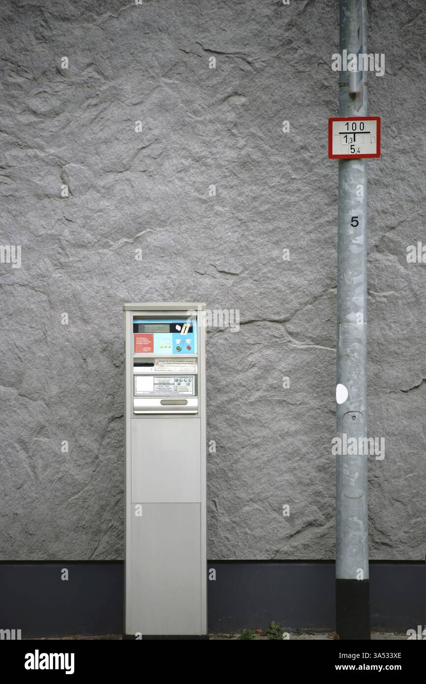 Un vecchio distributore automatico di biglietti o un distributore automatico di biglietti si trova di fronte a un muro d'impatto Foto Stock
