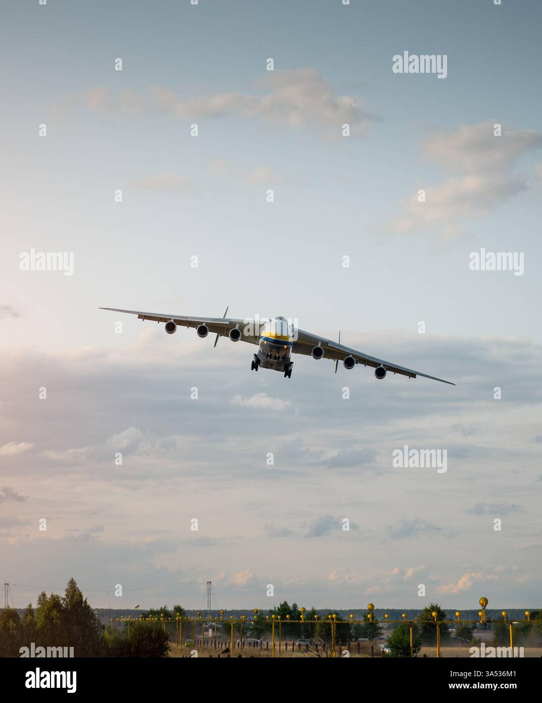 An-225 passando all'approccio finale. Vista frontale dell'enorme banchina di aerei cargo in una curva a sinistra e in discesa, carrello di atterraggio attivato. Foto Stock