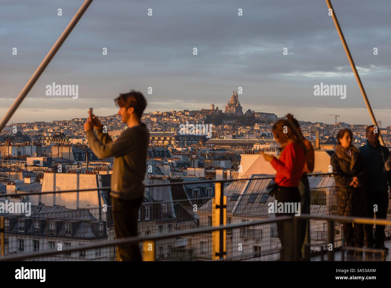 I visitatori si riuniscono sulla terrazza del Centre Pompidou a Parigi per guardare il tramonto e scattare foto del panorama. Foto Stock