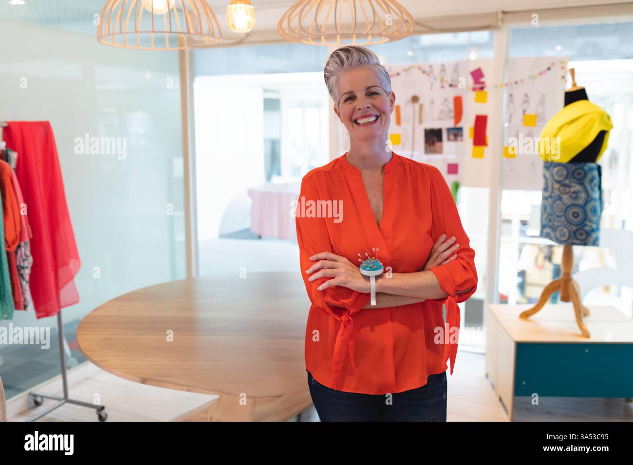 Donna sicura di sé in una blusa luminosa in uno studio di design moderno alla moda, spazio copia Foto Stock