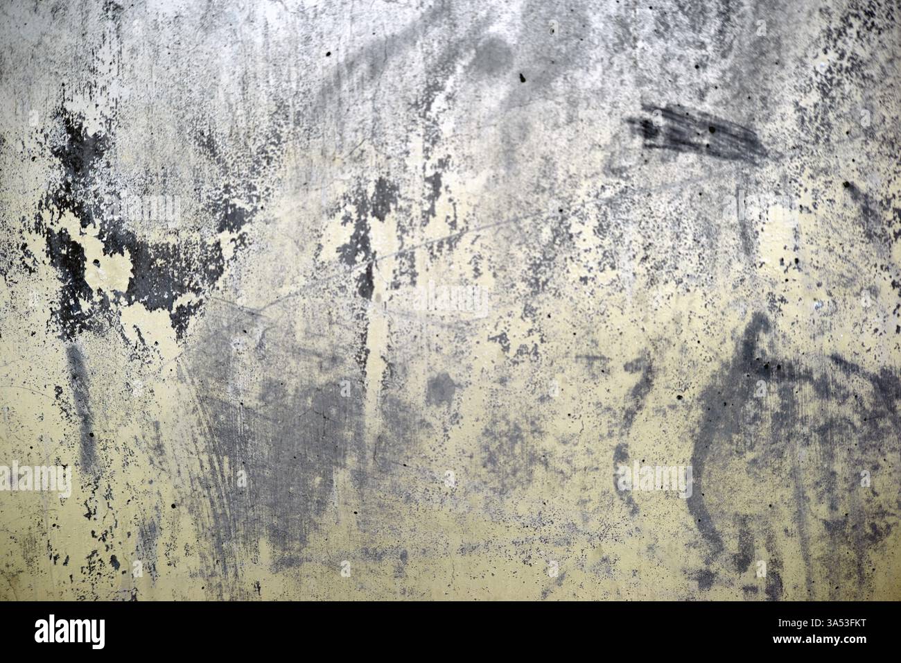 Il primo piano di una parete gialla con macchie di colore nero di vernice fuoriuscita sulla parete Foto Stock