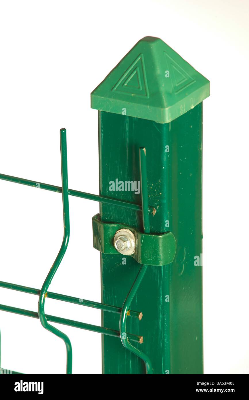 Immagine ravvicinata di un palo e di un cavo di recinzione in metallo verde, che evidenzia la parte superiore decorativa e gli elementi di fissaggio sicuro per un contorno da giardino robusto Foto Stock