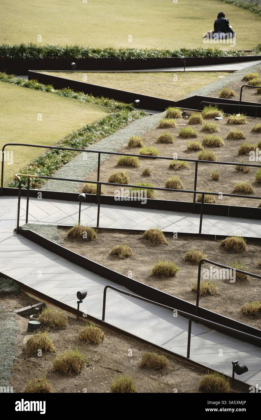 Los Angeles, Stati Uniti - 26 dicembre 2015: Un visitatore del museo siede su un prato nel giardino centrale creato da Robert Irwin al Getty Center in D. Foto Stock