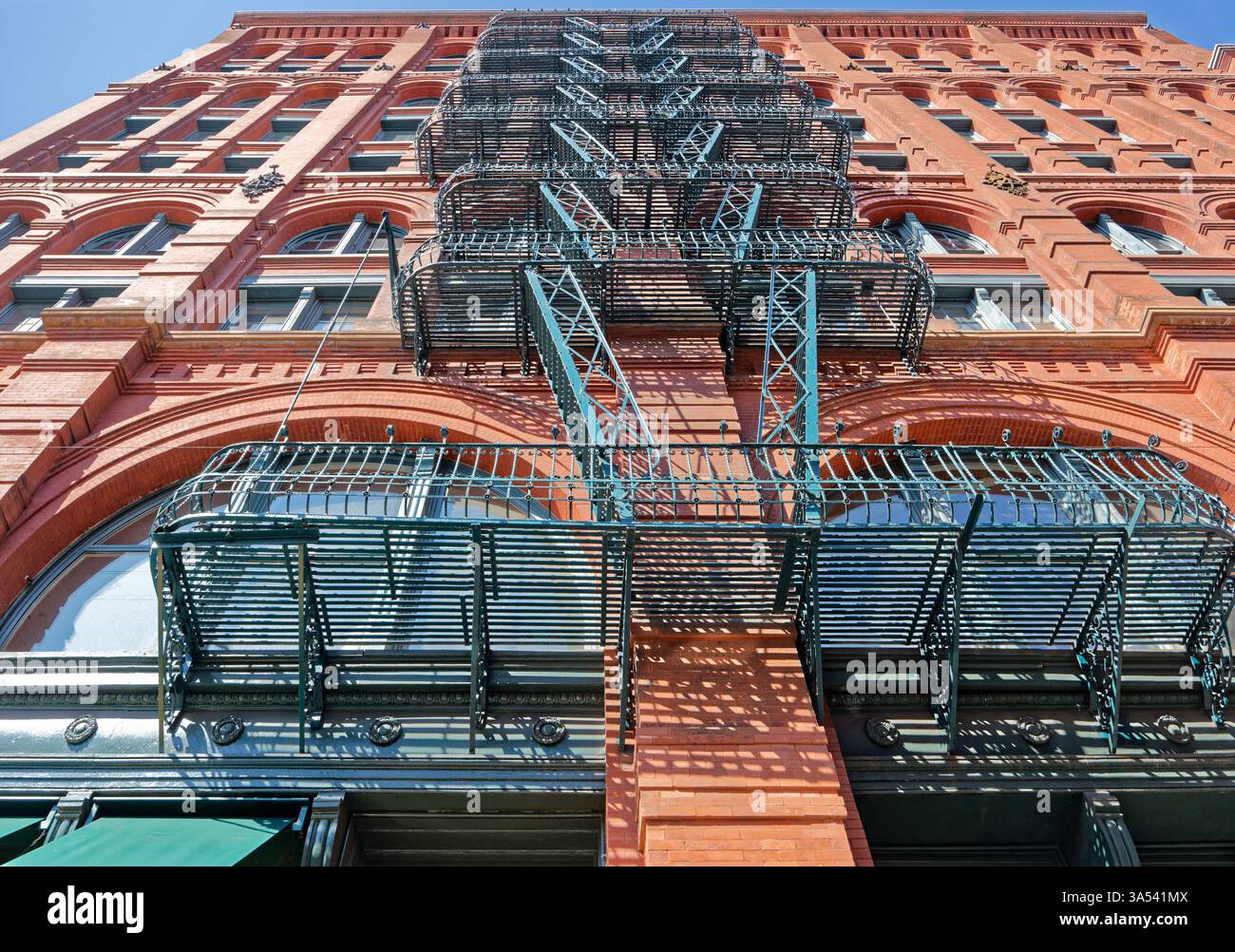 Guardando verso l'alto il fuoco verde sfugge sulla facciata di Mulberry Street del Puck Building. Foto Stock