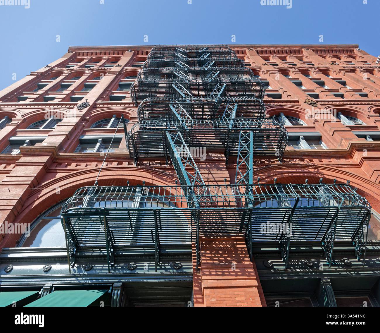 Guardando verso l'alto il fuoco verde sfugge sulla facciata di Mulberry Street del Puck Building. Foto Stock