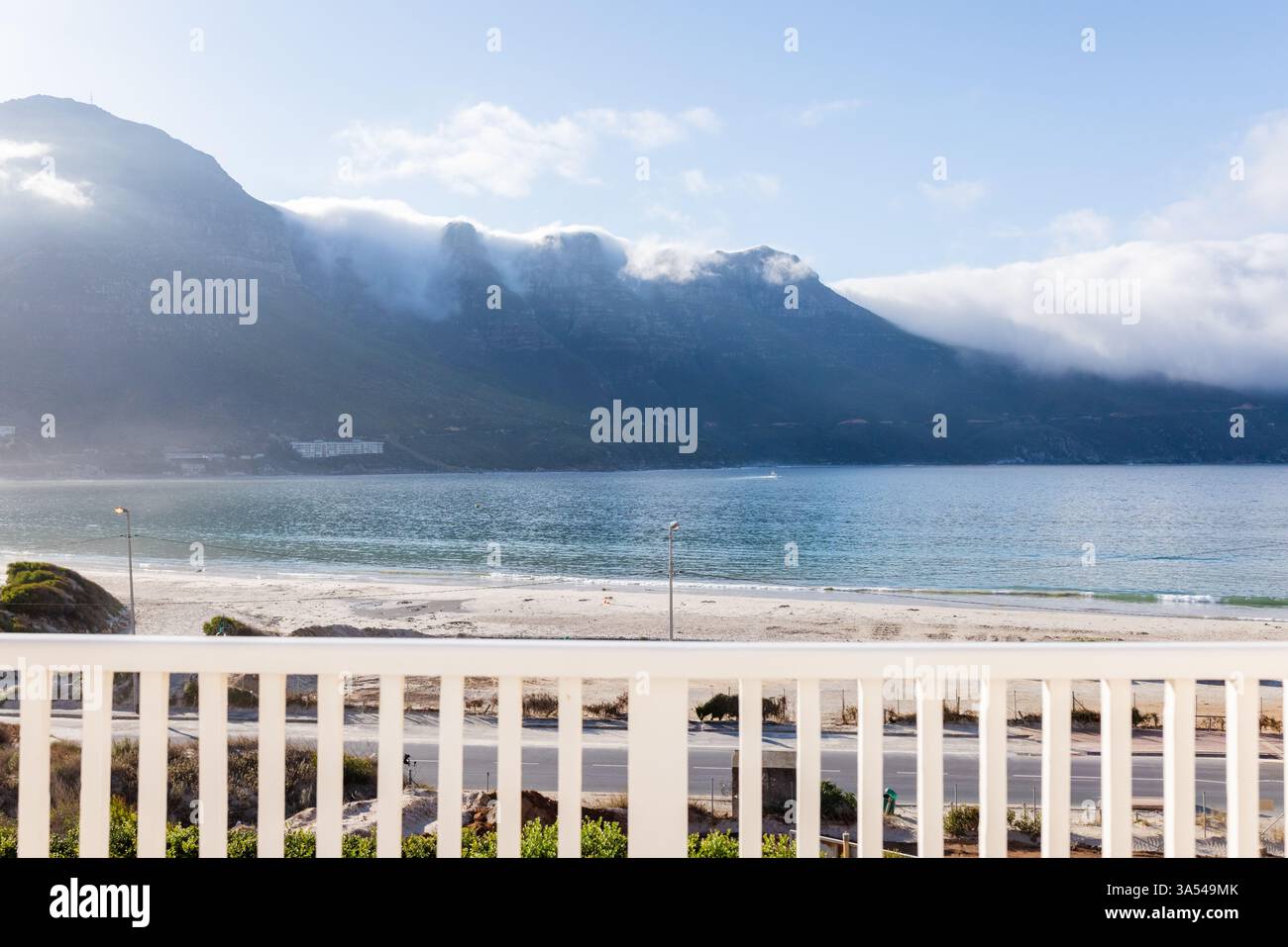 Vista panoramica dell'oceano dal balcone che si affaccia sulla tranquilla spiaggia e sulle maestose montagne, spazio per fotocopie Foto Stock