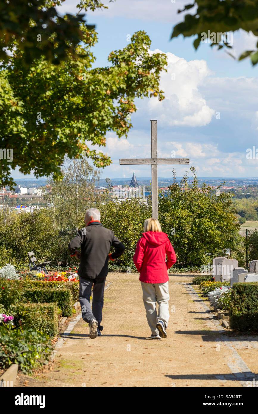 Andachtskreuz und Besucher auf dem Heidebergfriedhof, im Hintergrund die Trinitatiskirche, Riesa, Sachsen, Deutschland *** Croce devozionale e sito Foto Stock