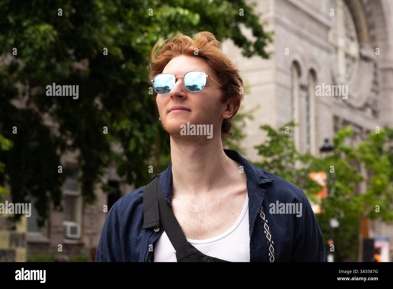 Un giovane con fiducia in occhiali da sole, che si gode un pomeriggio di sole Foto Stock