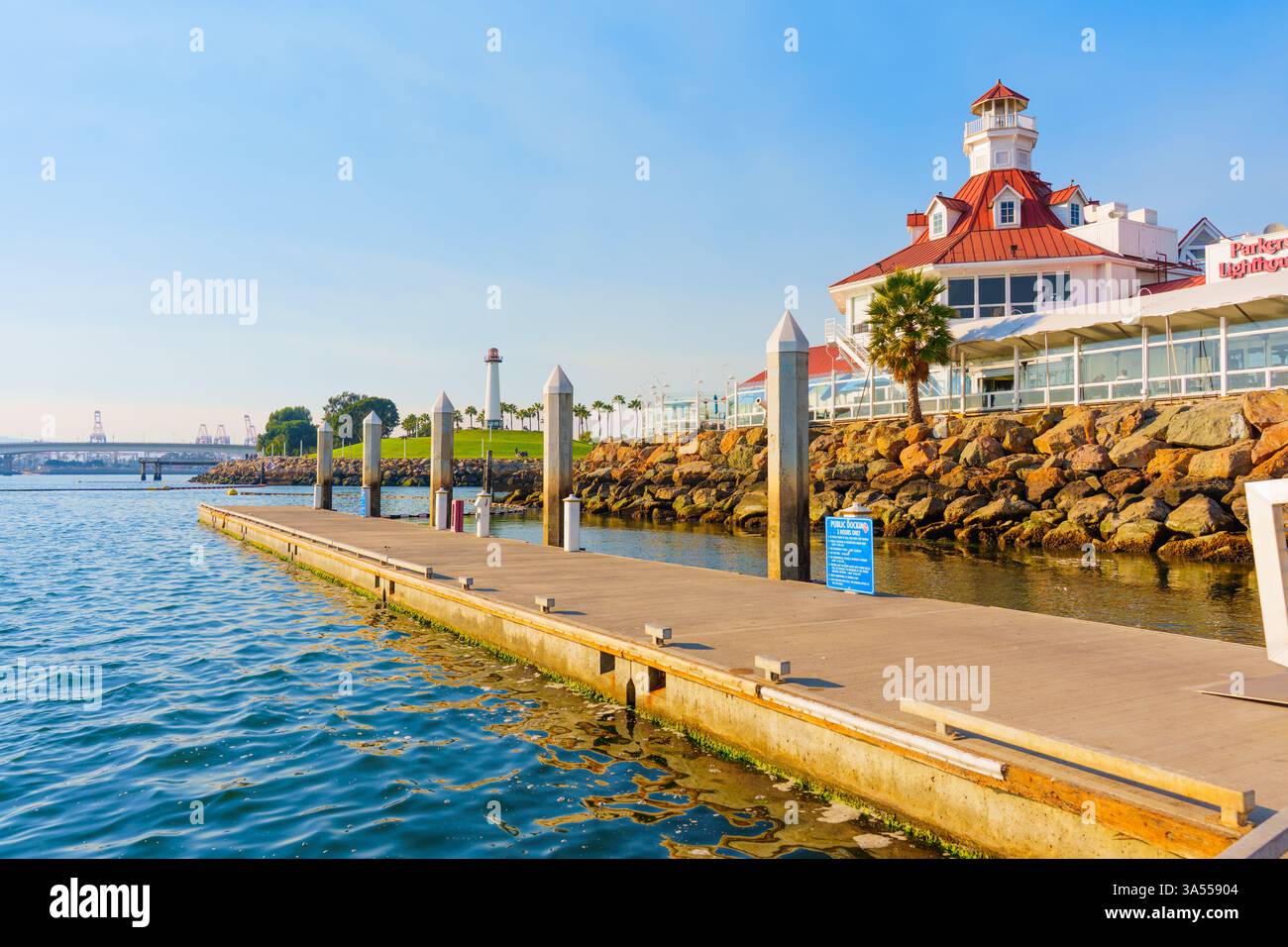 Long Beach, California - 11 gennaio 2025: Luminoso scenario sul lungomare con il faro di Parker, un ristorante di pesce, con un molo di legno che si estende su i Foto Stock