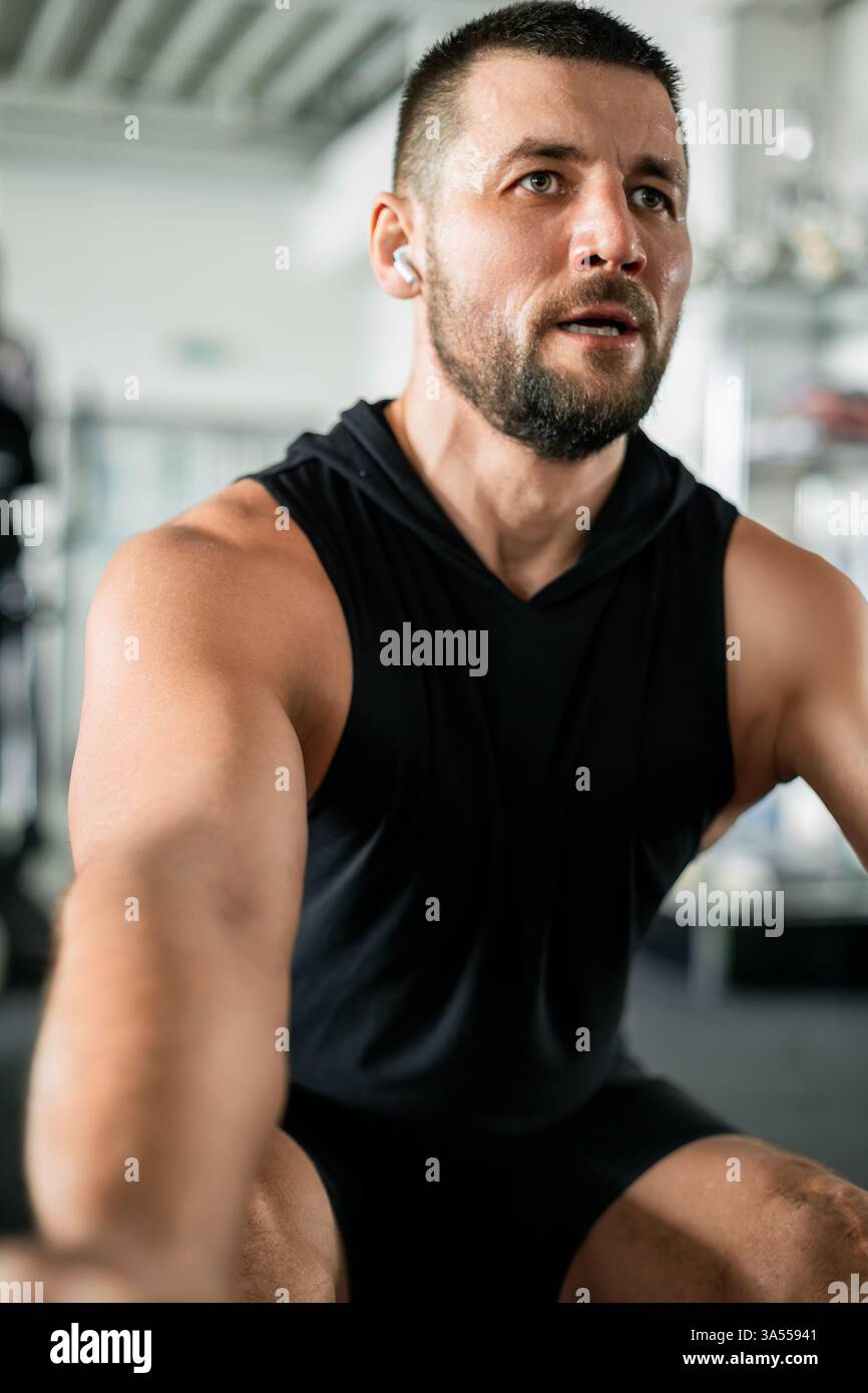 Allenamento muscolare concentrato in palestra, sudorazione e determinazione Foto Stock