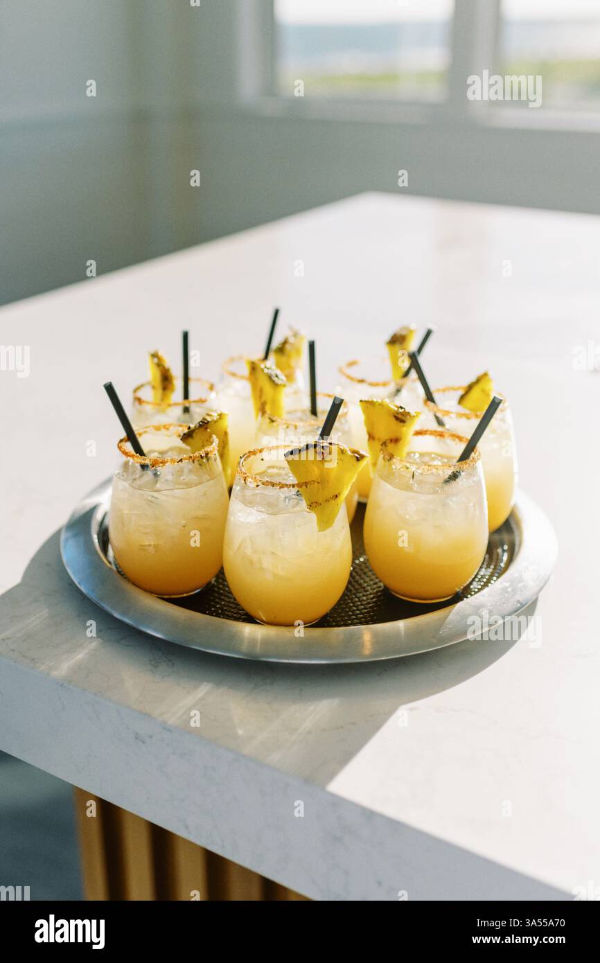 verticale di bevande gialle con guarnizione di ananas alla luce del sole Foto Stock